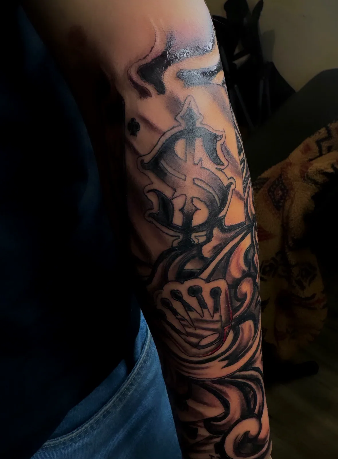 Black-and-grey ornamental filigree forearm sleeve featuring a crown motif.